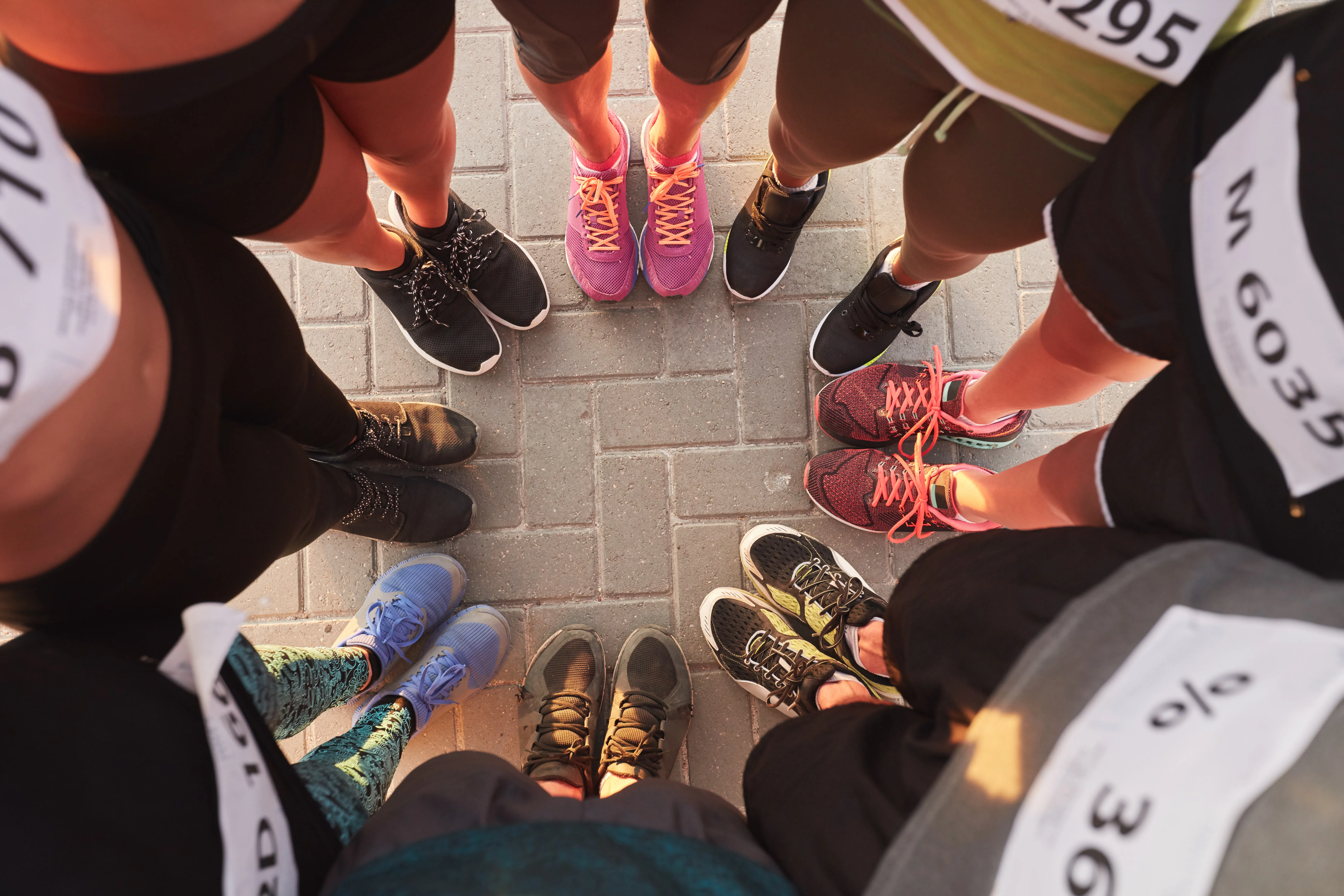 Runners with race bibs standing in a circle
