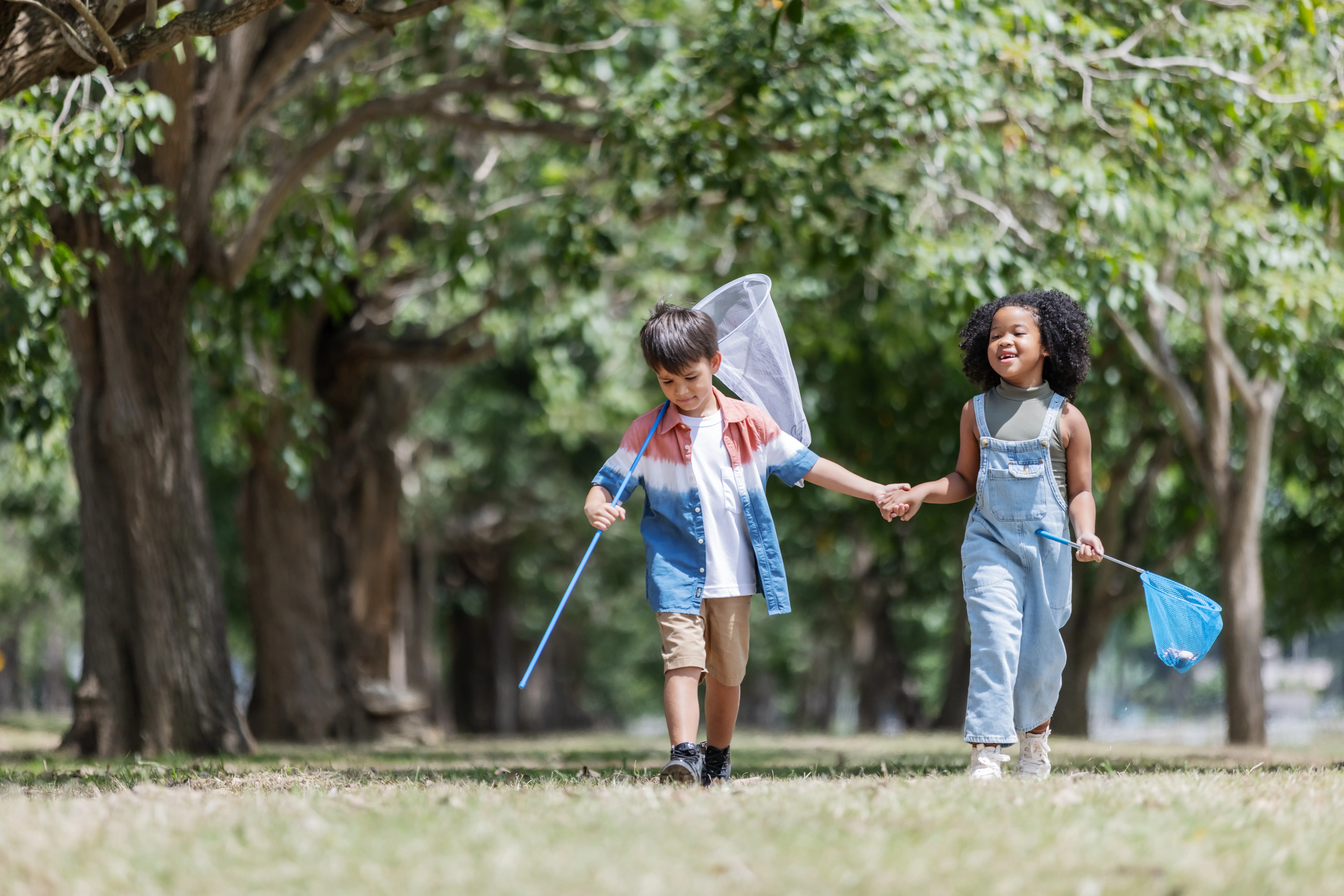 Two kids walking hand in hand in the park